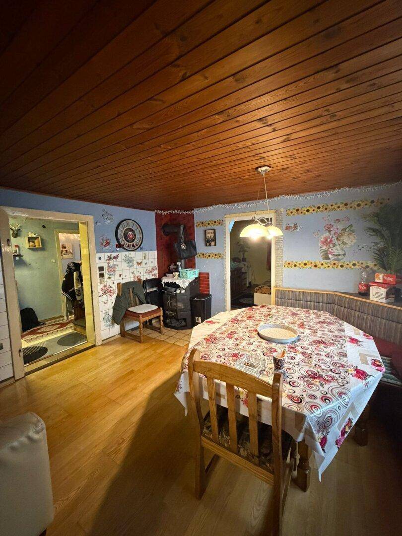 Gemütlicher Essbereich mit Holztisch, Eckbank und Holzdecke, rustikal eingerichtet.