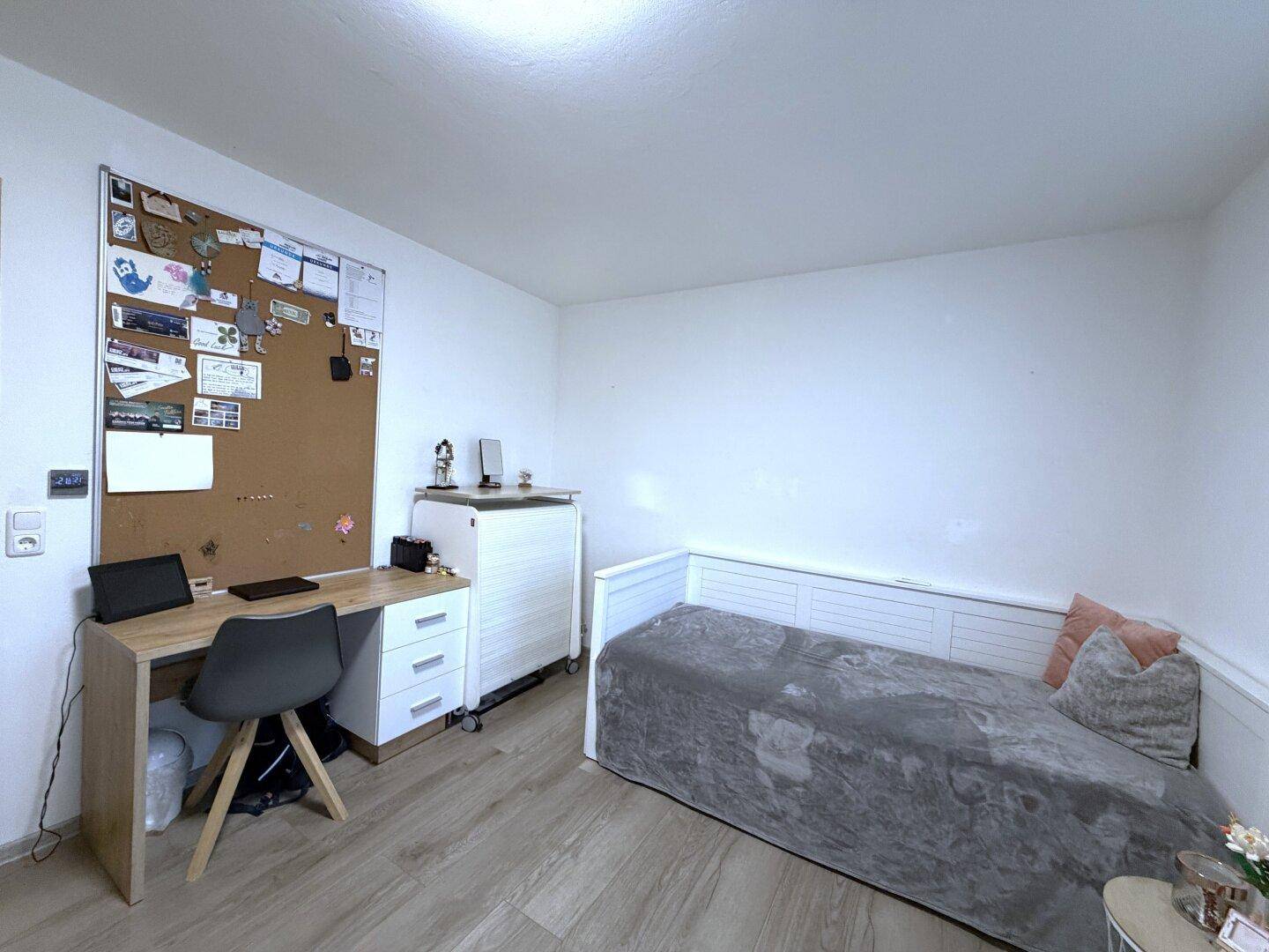 Arbeitszimmer oder Gästezimmer mit Holzboden, Schreibtisch und Tagesbett.