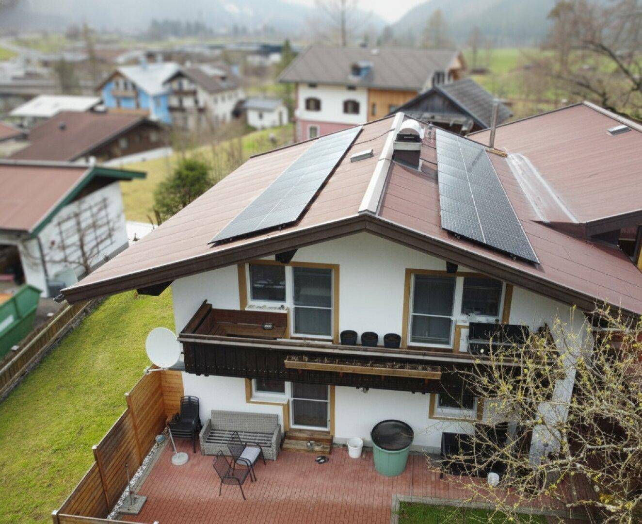 Dach des Hauses mit installierten Photovoltaikmodulen und Blick auf die Umgebung.