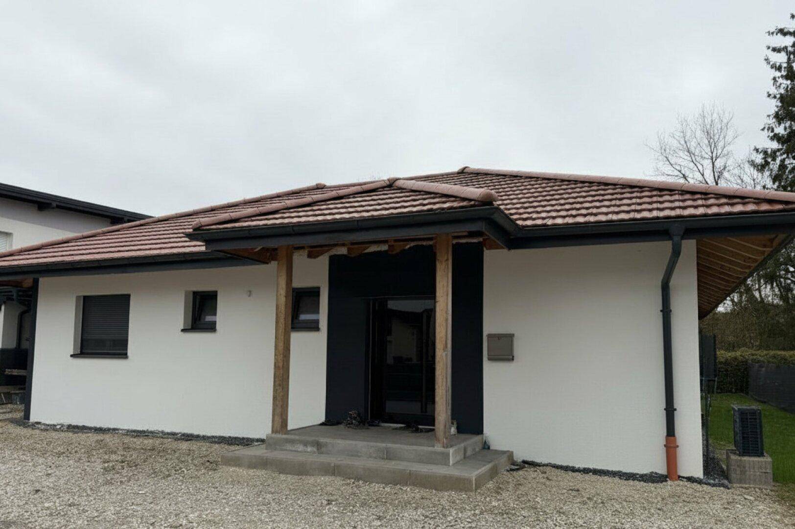 Moderne Hausfassade mit einladendem Eingangsbereich und traditionellem Ziegeldach.