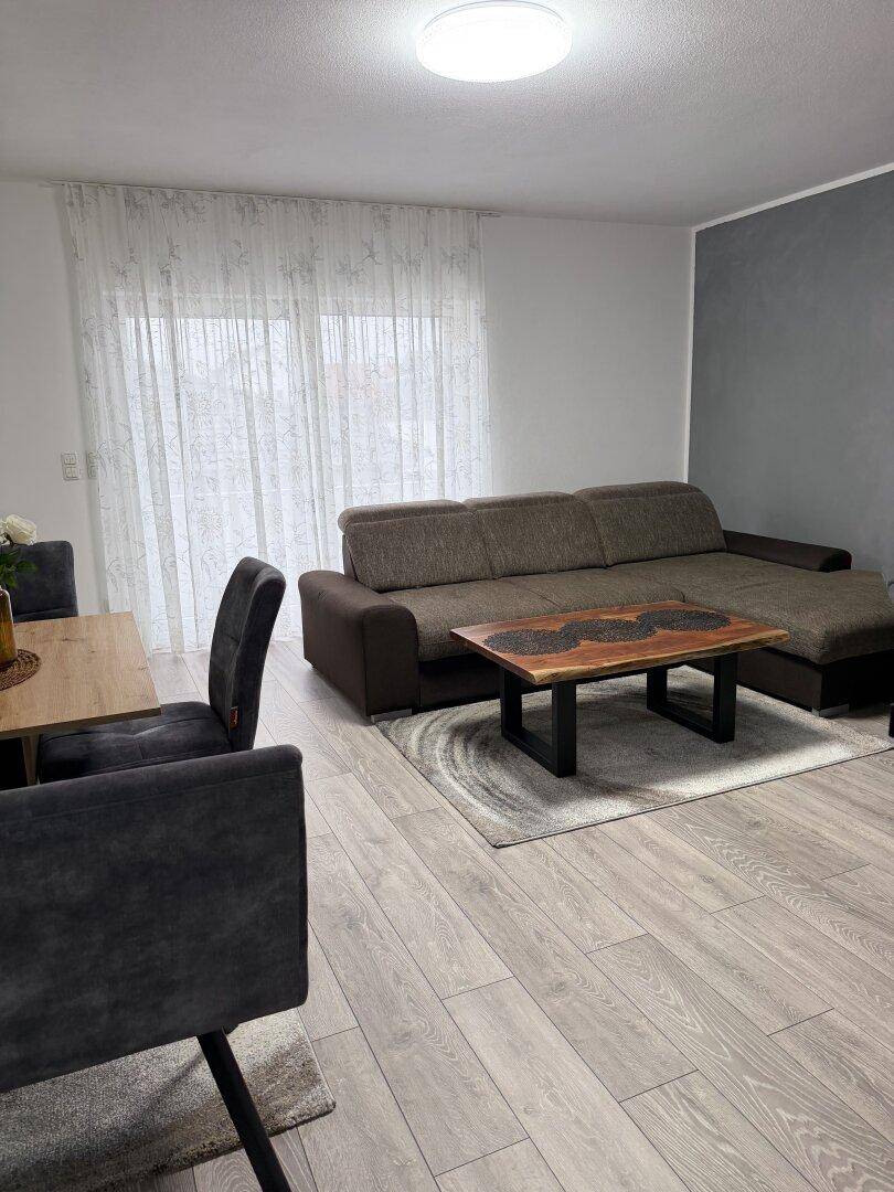 Gemütlicher Wohnbereich mit Sofa, Couchtisch und Holzboden.