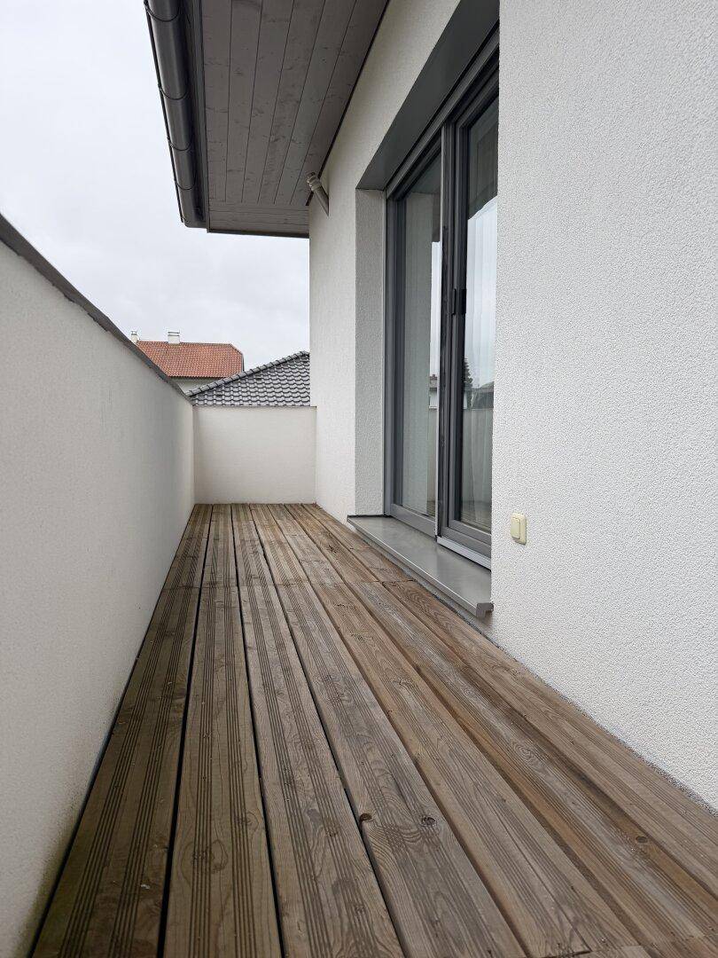 Schmaler Holzbalkon mit Blick auf die Umgebung.