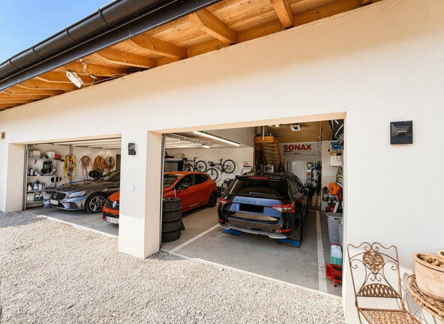 Doppelgarage mit zwei Toren und Zufahrt zum Haus.