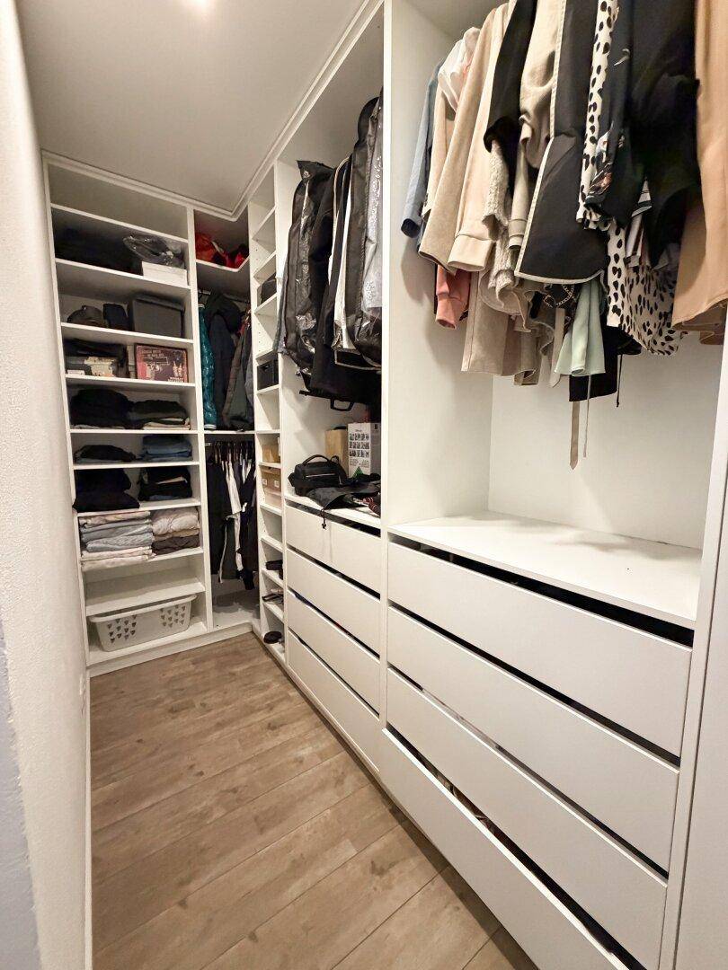 Praktischer begehbarer Kleiderschrank mit vielen Fächern und Schubladen für optimale Organisation.