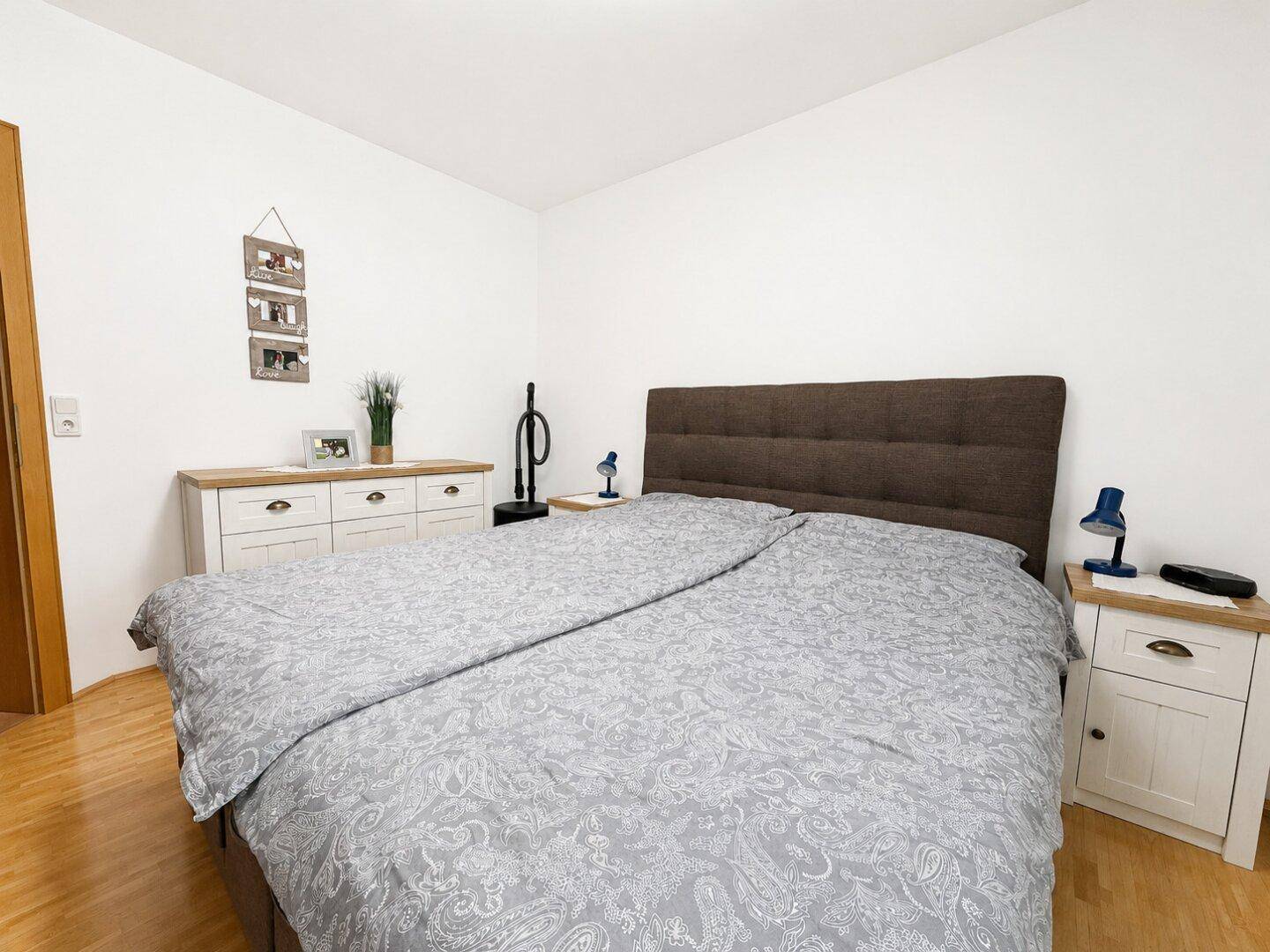 Gemütliches Schlafzimmer mit Doppelbett, Nachttischen und Parkettboden.
