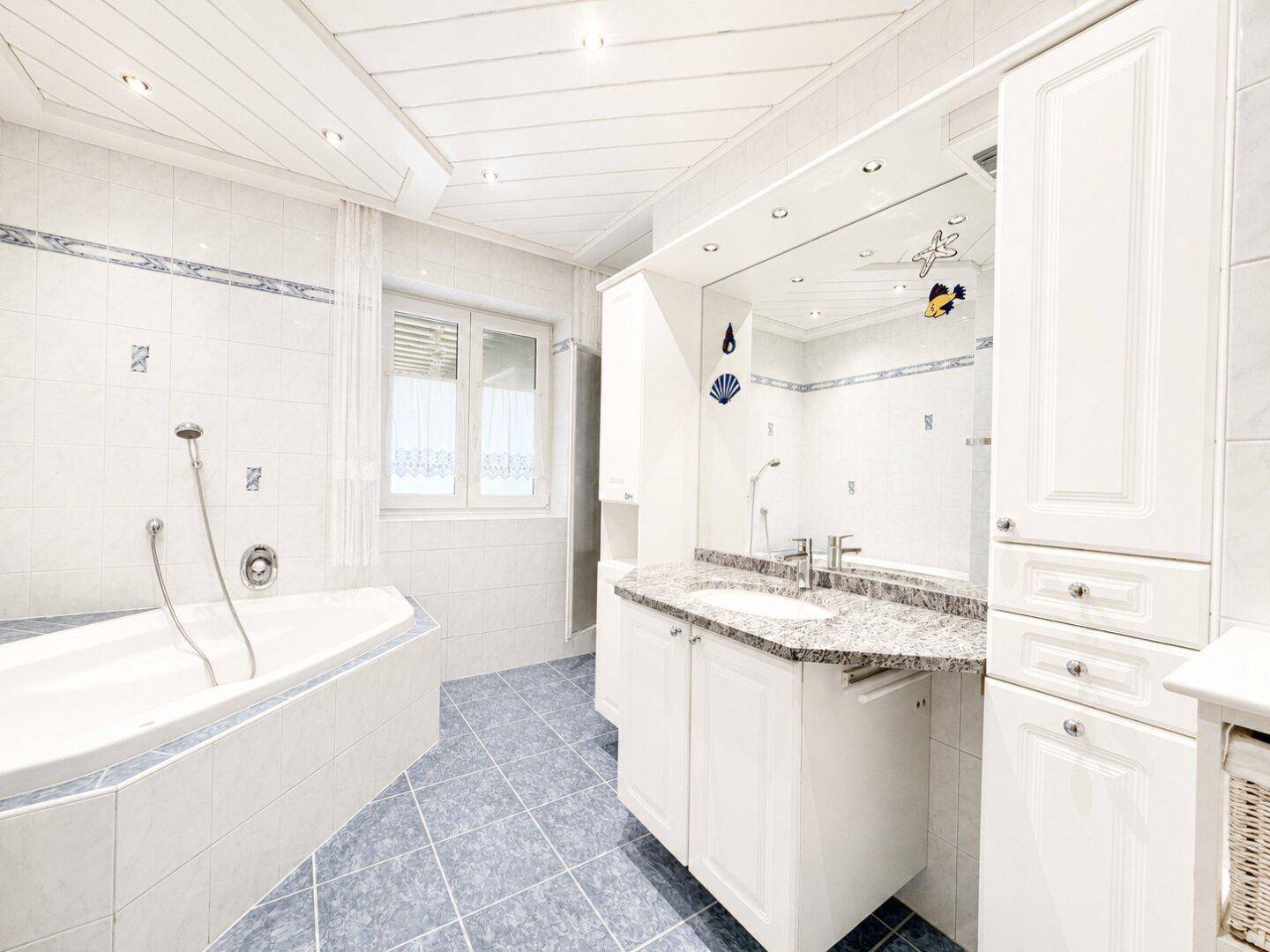 Geräumiges Badezimmer mit Eckbadewanne, Doppelwaschbecken und Granit-Arbeitsplatte.