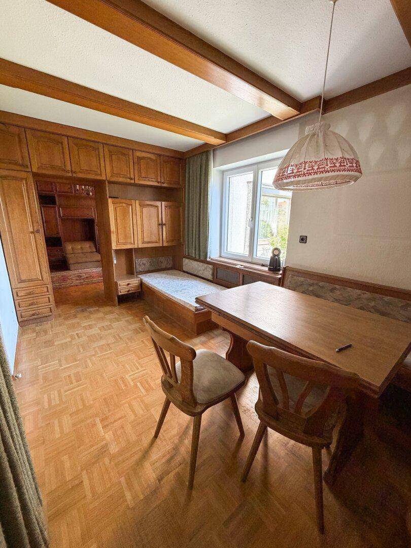 Essbereich mit rustikalen Holzmöbeln, Holzbalkendecke und Parkettboden, ideal für gesellige Mahlzeiten.