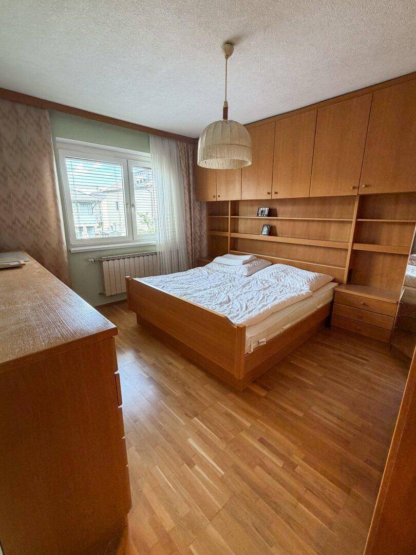 Schlafzimmer mit Doppelbett, Einbauschränken und Holzboden.