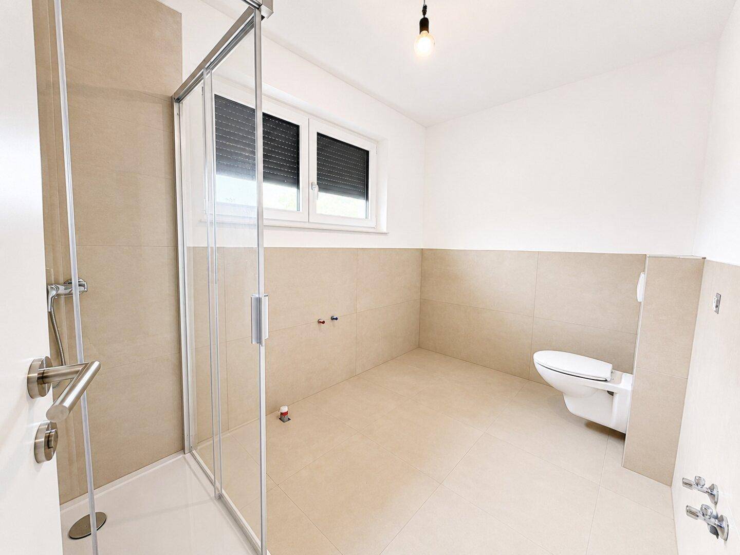 Modernes Badezimmer mit begehbarer Dusche, Wand-WC und Fenster.