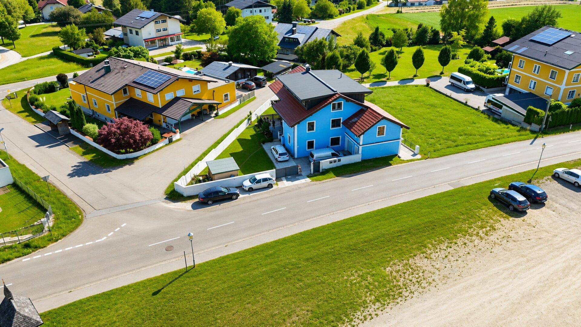 Weitläufige Luftaufnahme des Hauses in einer Wohnsiedlung mit viel Grün und umliegenden Gebäuden.