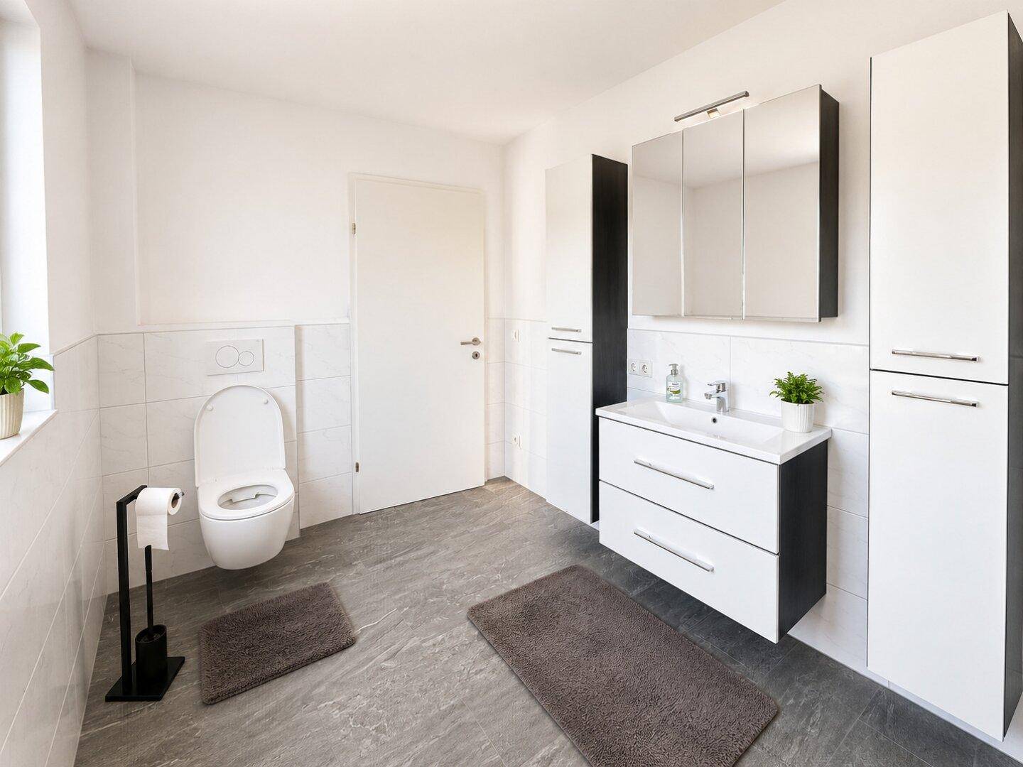 Modernes Badezimmer mit WC, Einzelwaschbecken, Spiegelschrank und grauen Fliesen.