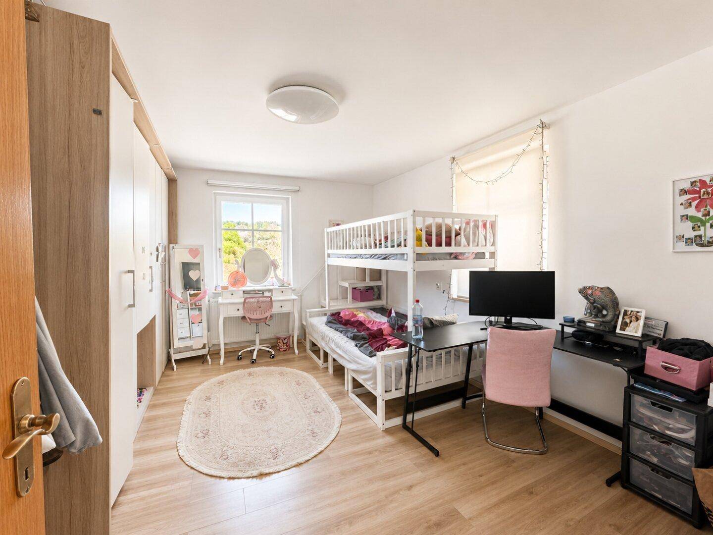 Kinderzimmer mit Etagenbett, Schreibtisch und Kleiderschrank, ideal für Geschwister oder Gäste.