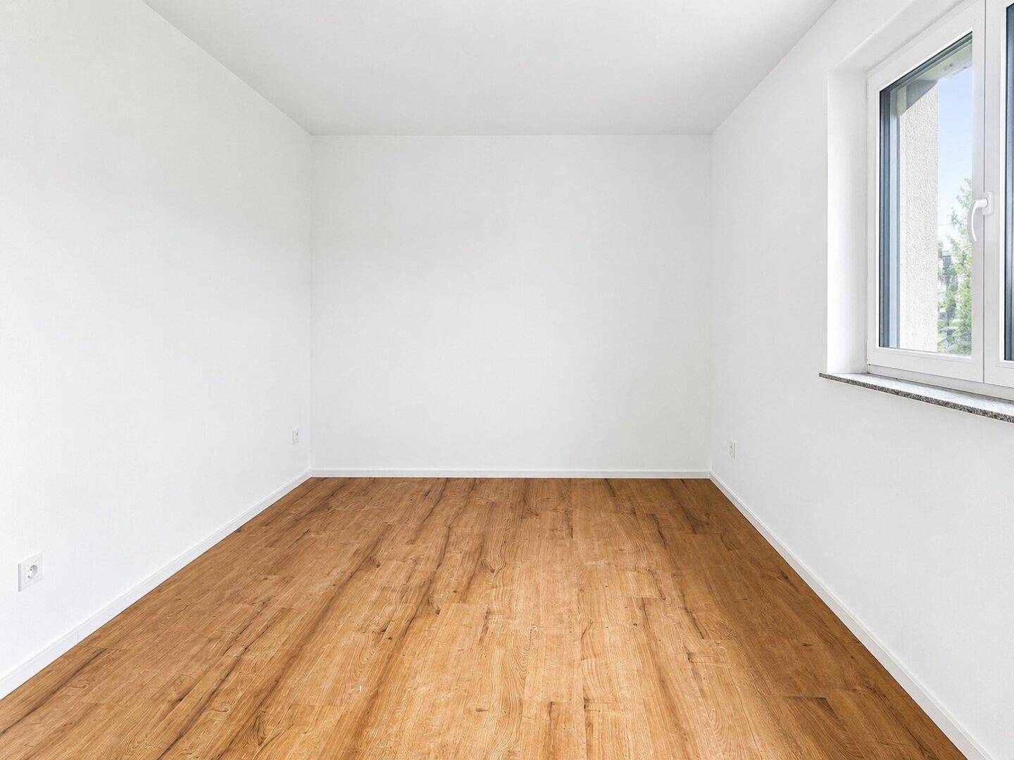 Schlichtes Schlafzimmer mit Laminatboden und einem Fenster für natürliche Belichtung.