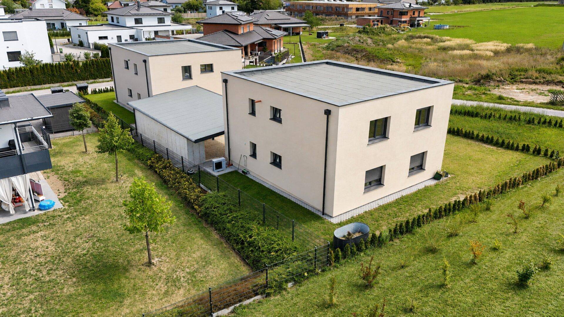 Moderne Neubau-Doppelhaushälfte mit Flachdach und gepflegtem Gartenbereich.
