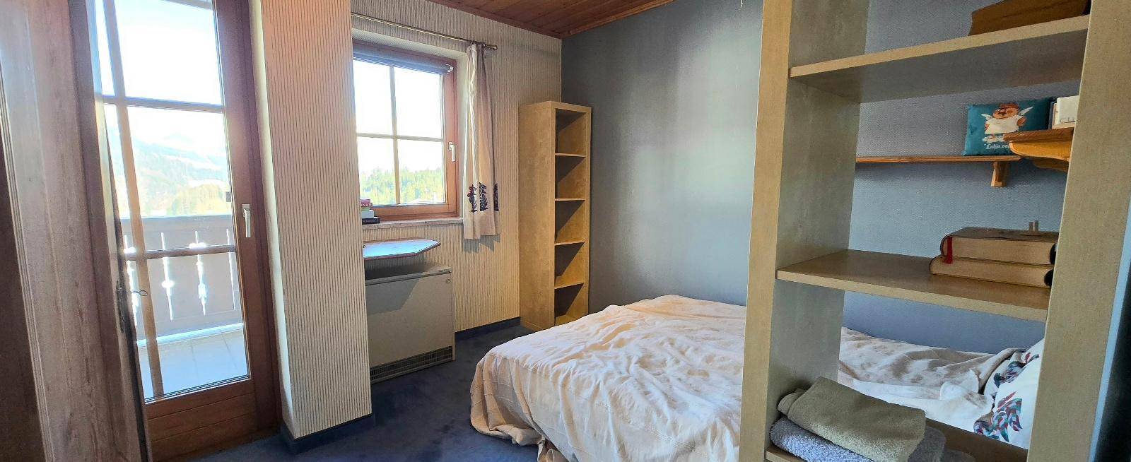 Gemütliches Schlafzimmer mit Zugang zum Balkon, Blick auf die Berge und viel natürlichem Licht.