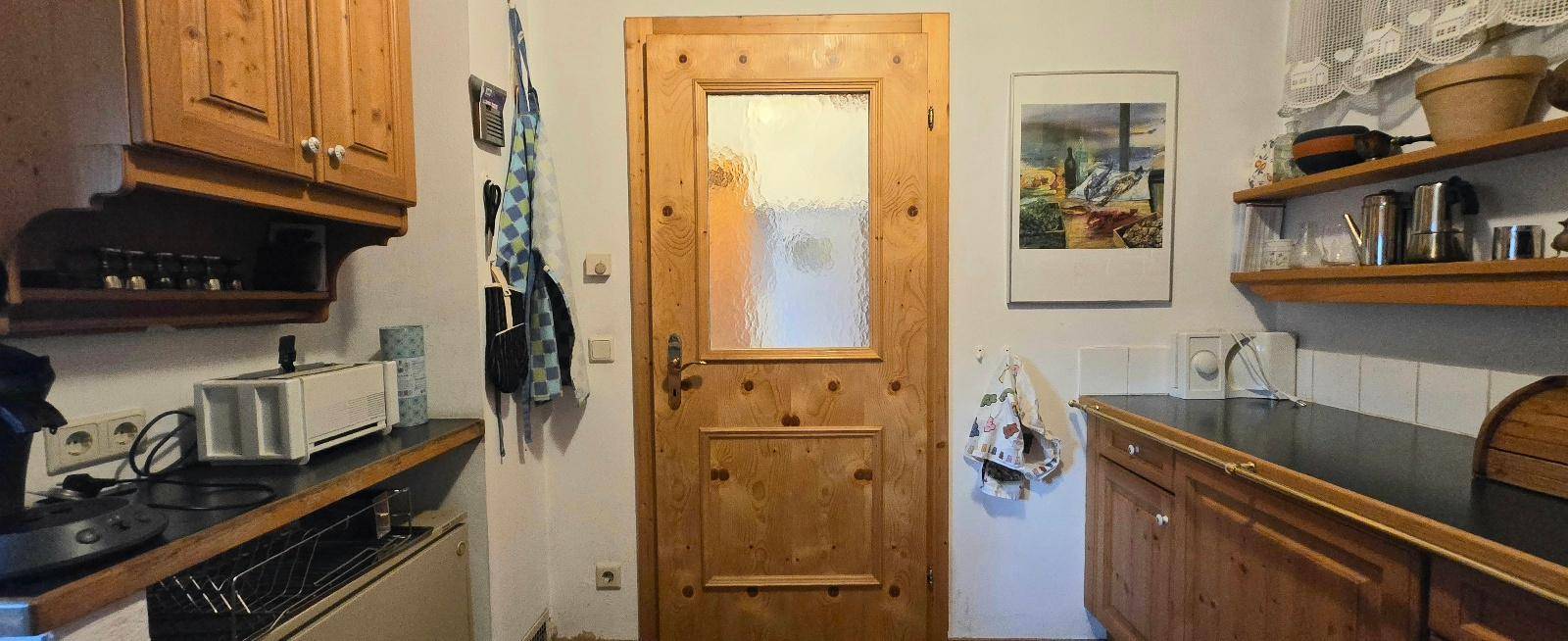 Traditionelle Holzküche mit Einbauschränken, integriertem Backofen und rustikalem Charme.
