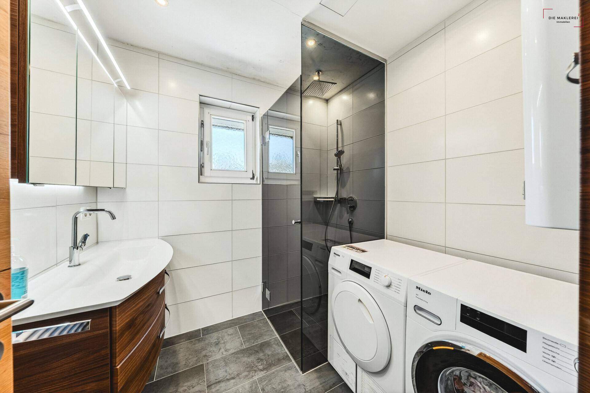 Modernes Badezimmer mit begehbarer Dusche, Waschmaschine und Fenster.