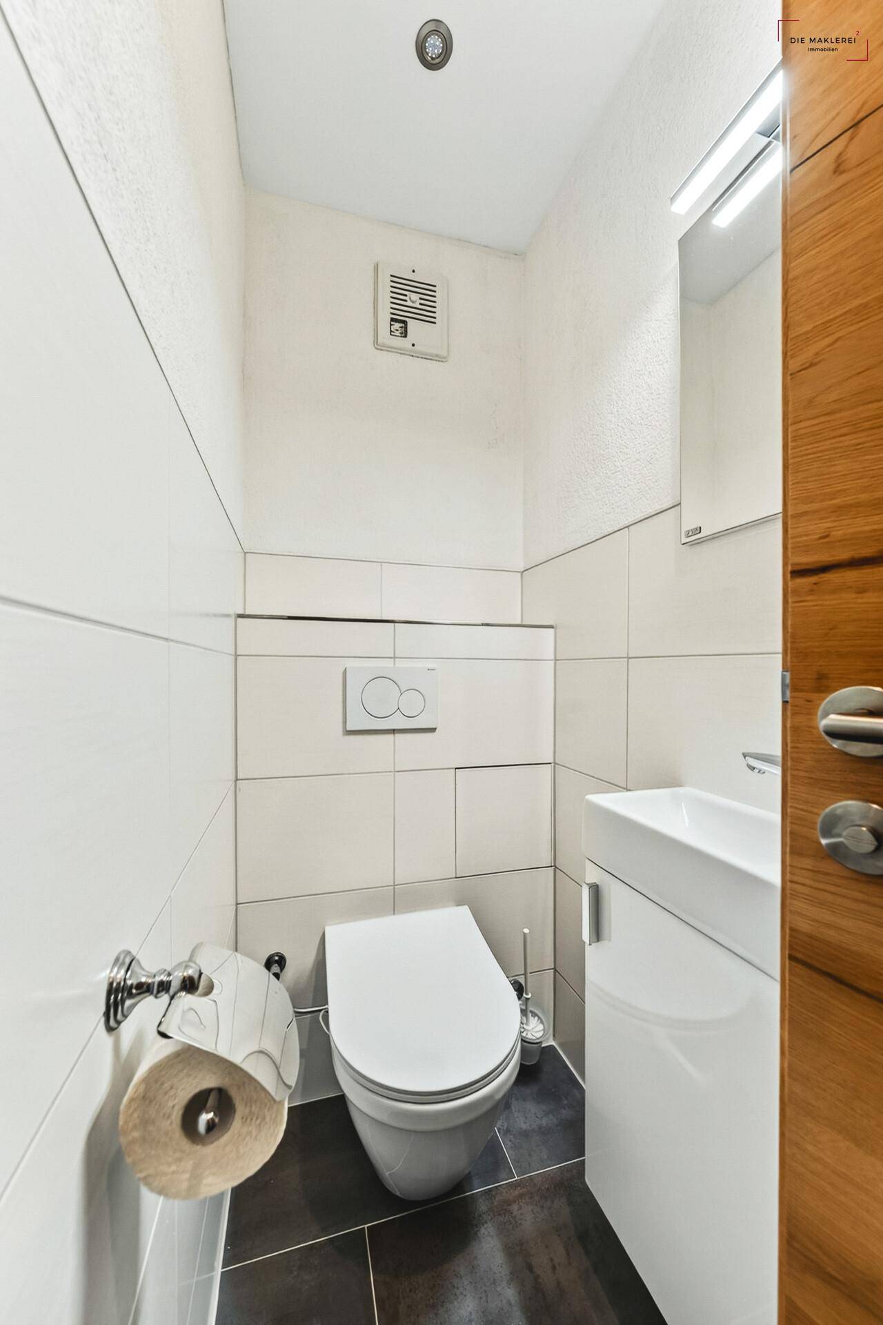 Kleines Gäste-WC mit wandhängender Toilette und modernem Waschbecken.