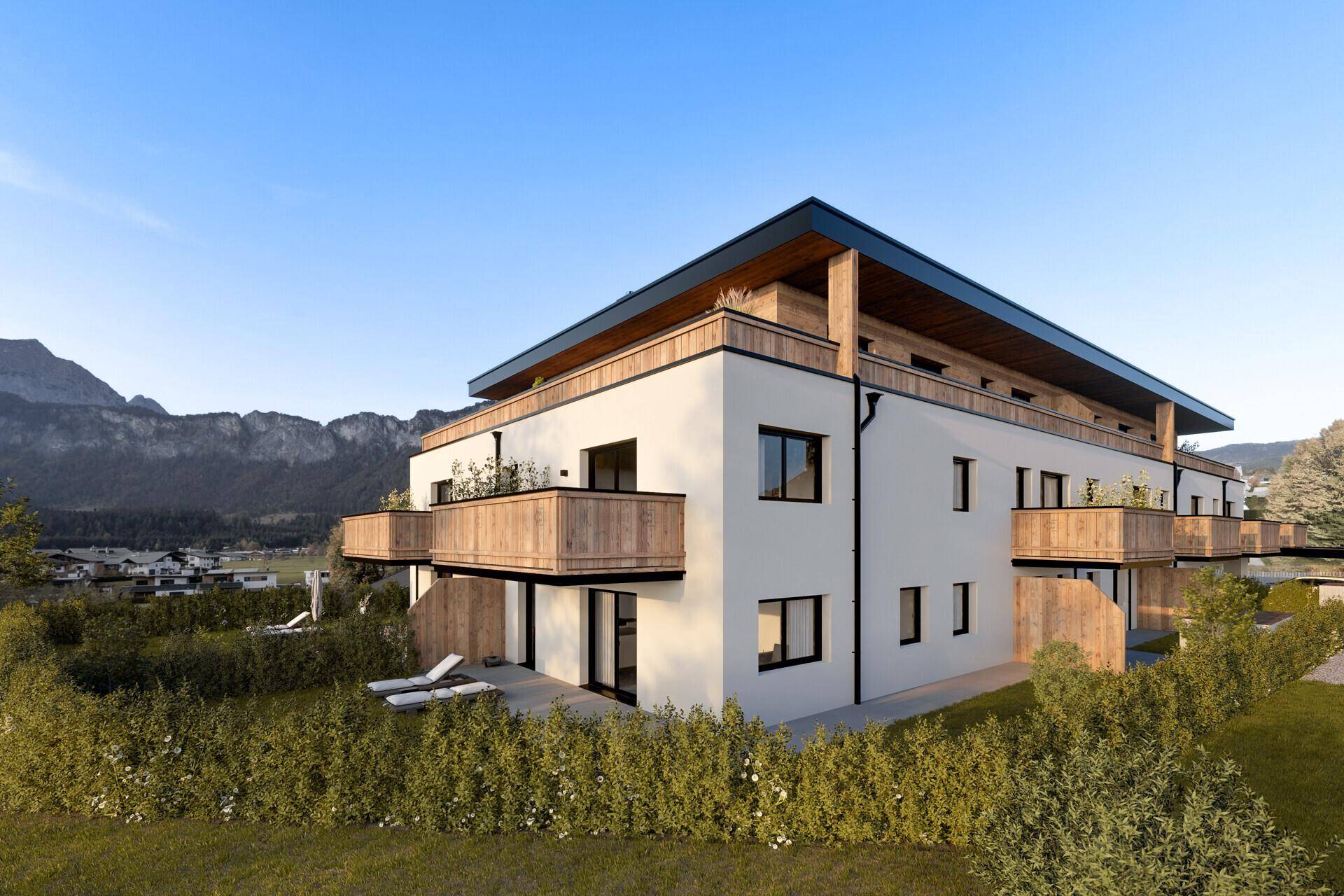 Neubau-Wohngebäude mit moderner Architektur, Holzverkleidung und Balkonen, eingebettet in eine grüne Landschaft.