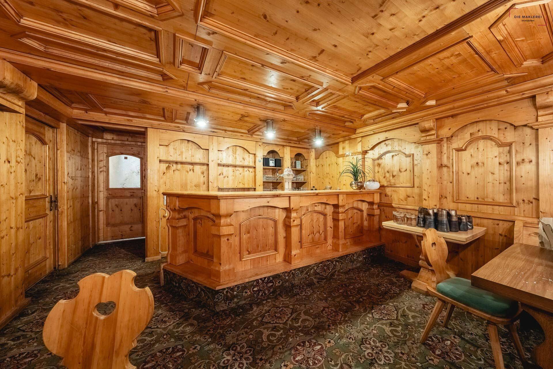 Traditioneller Restaurantbereich mit einer Holzbar, Holztäfelung und gemütlichen Sitzgelegenheiten.