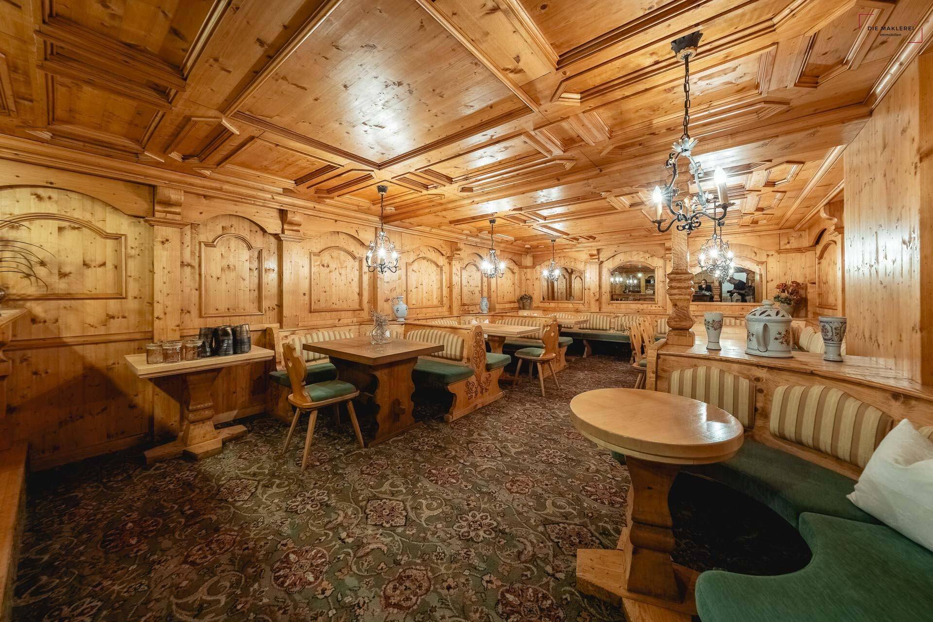 Rustikales Restaurant im alpenländischen Stil mit viel Holzvertäfelung und traditionellen Sitzgelegenheiten.