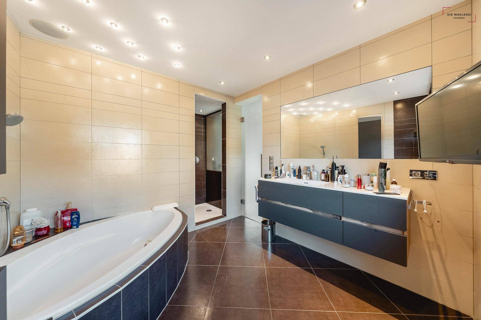 Großes Badezimmer mit Badewanne, separater Dusche, Doppelwaschtisch und großem Spiegel.