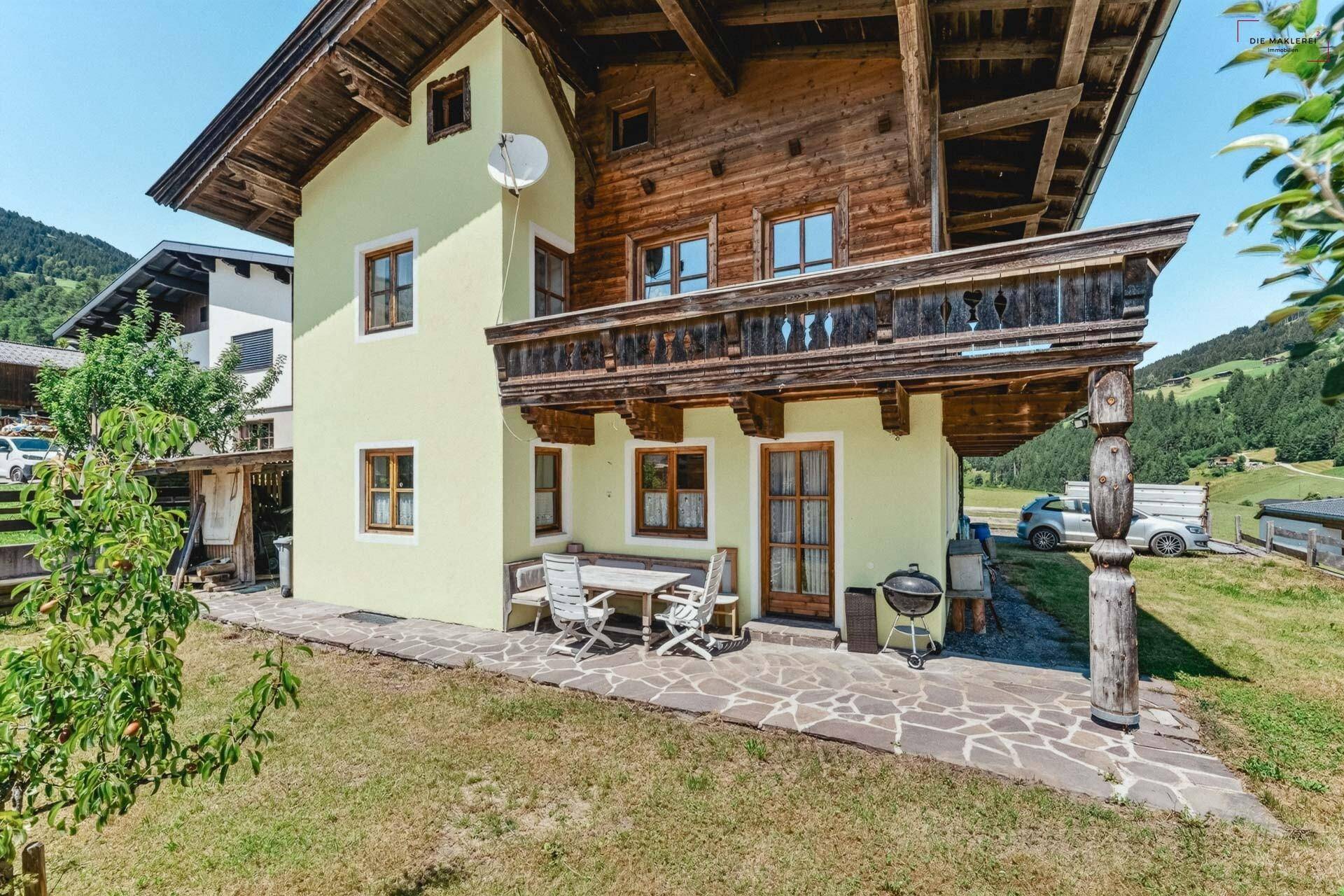 Gemütliche Terrasse am Haus mit Gartenmöbeln und Blick ins Grüne und die Berge.
