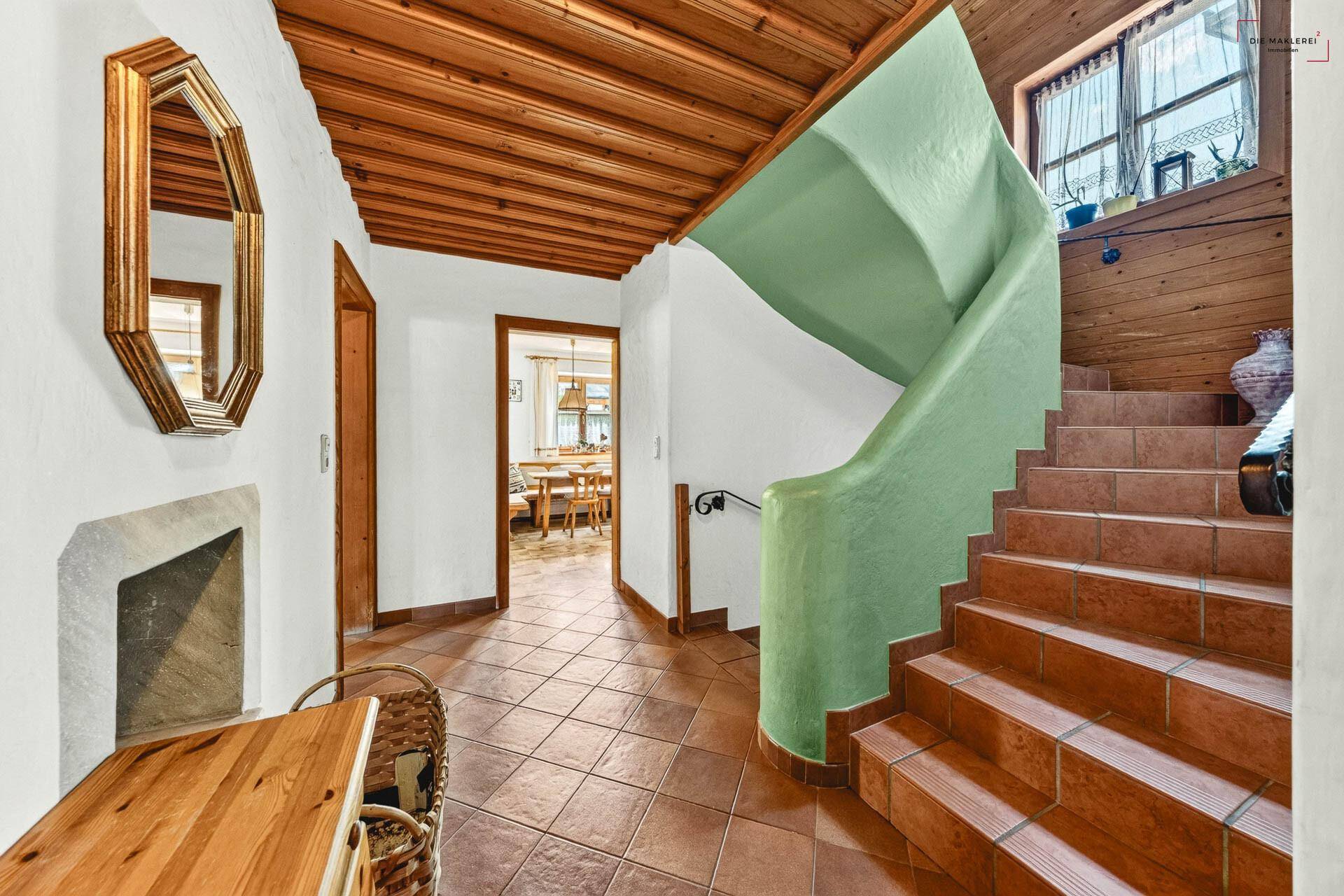 Traditioneller Eingangsbereich mit Holzdecke, gefliestem Boden und geschwungener Treppe zum Obergeschoss.
