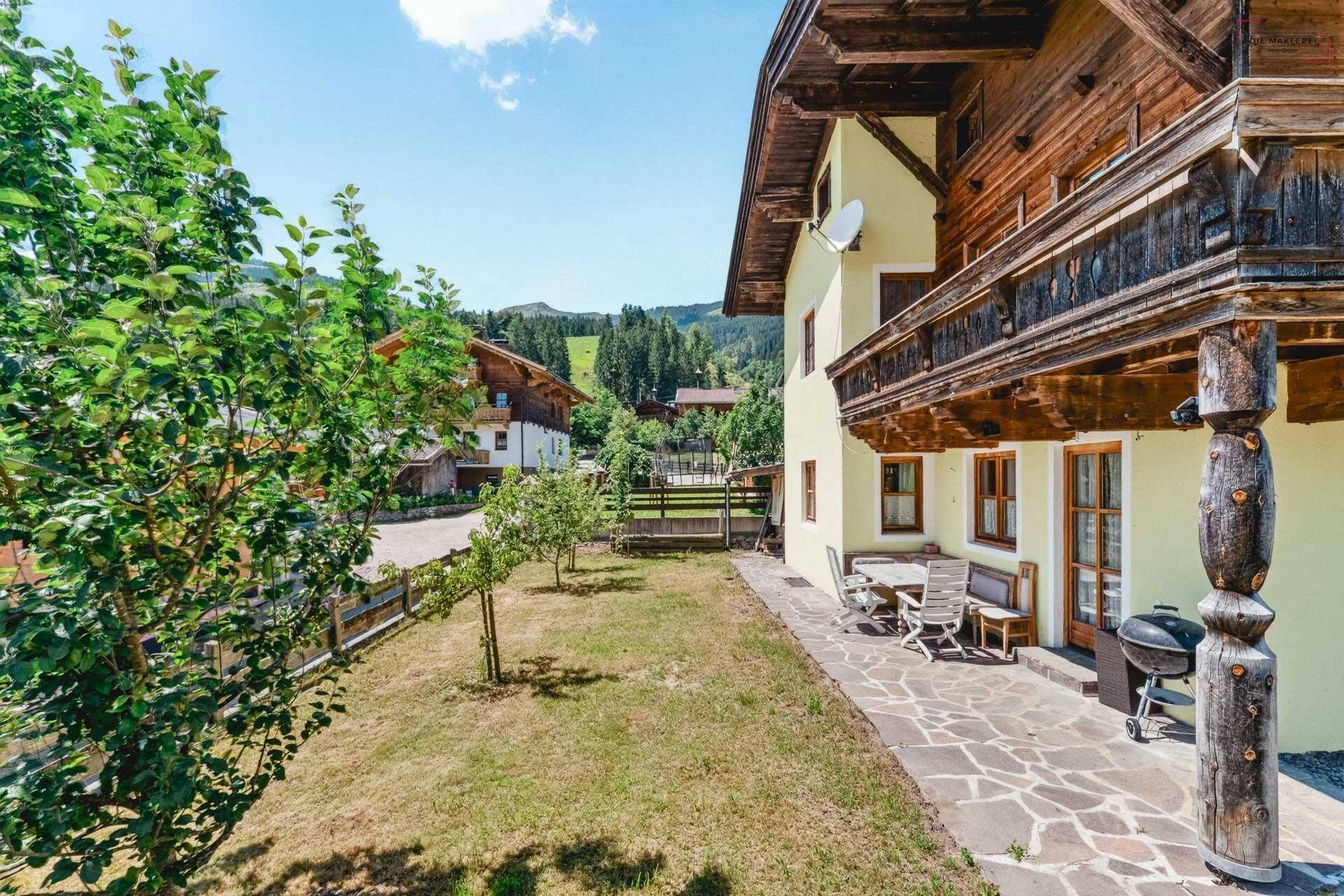 Terrasse mit Sitzgelegenheiten, Grill und Zugang zum Gartenbereich des Hauses.