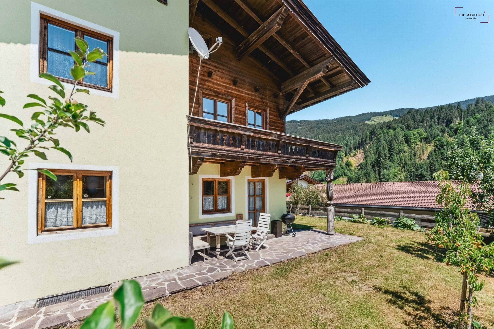 Traditionelles Chalet mit Holzfassade, Balkon und einer gemütlichen Terrasse mit Bergblick.