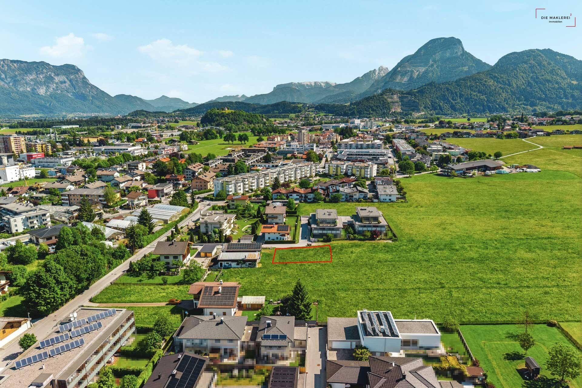 Übersicht aus der Vogelperspektive eines Baugrundstücks in einer Siedlung mit Bergsicht.
