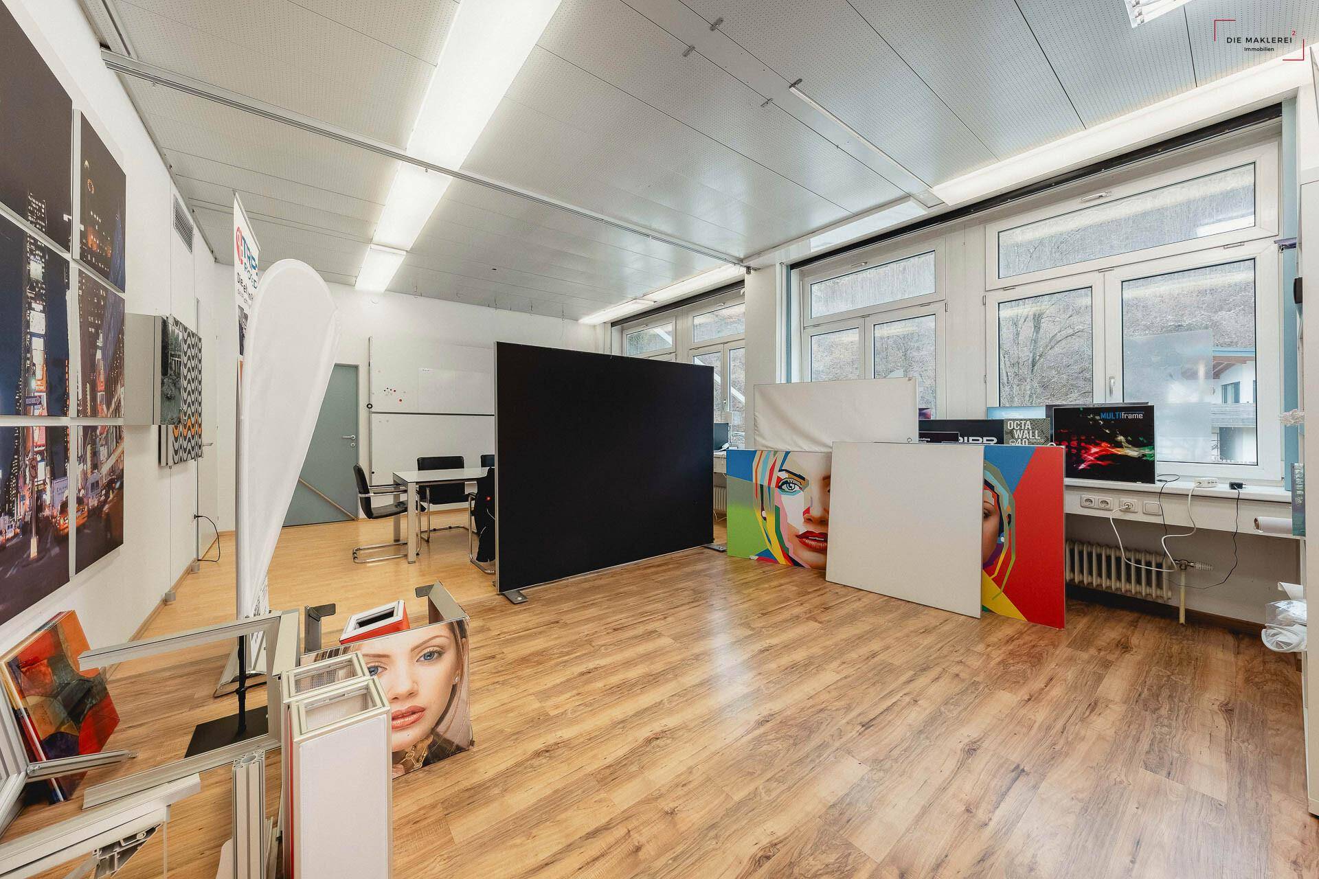 Kreativer Arbeitsraum oder Studio mit Laminatboden, großen Fenstern und verschiedenen Ausstellungsstücken.