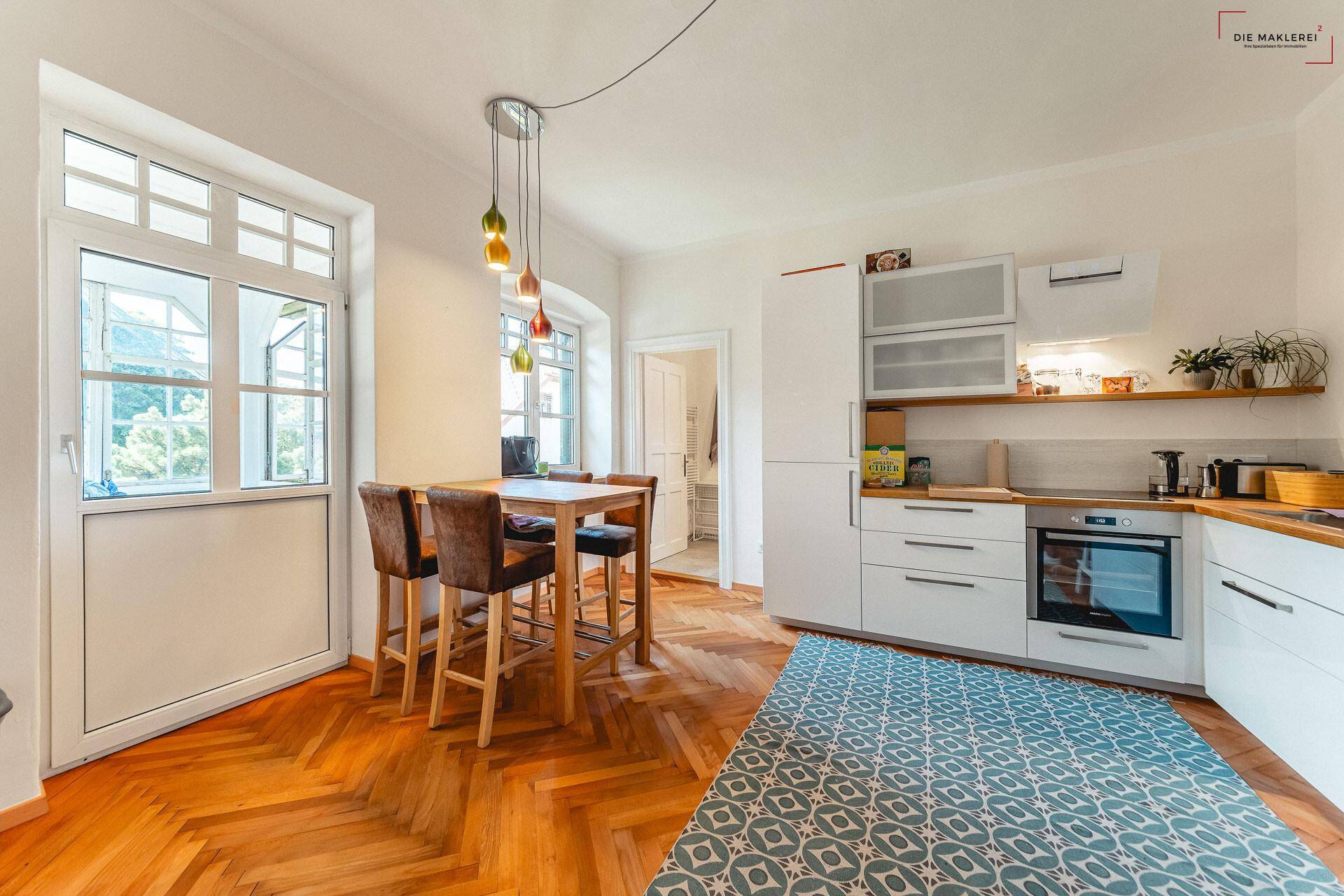 Moderne Einbauküche mit Essbereich, Holzboden und direktem Zugang zum Garten.