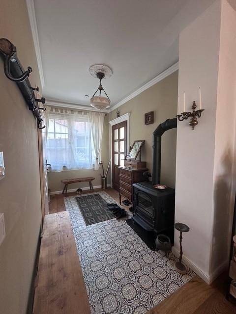 Eingangsbereich mit Holzofen, gemusterten Fliesen und Garderobe.