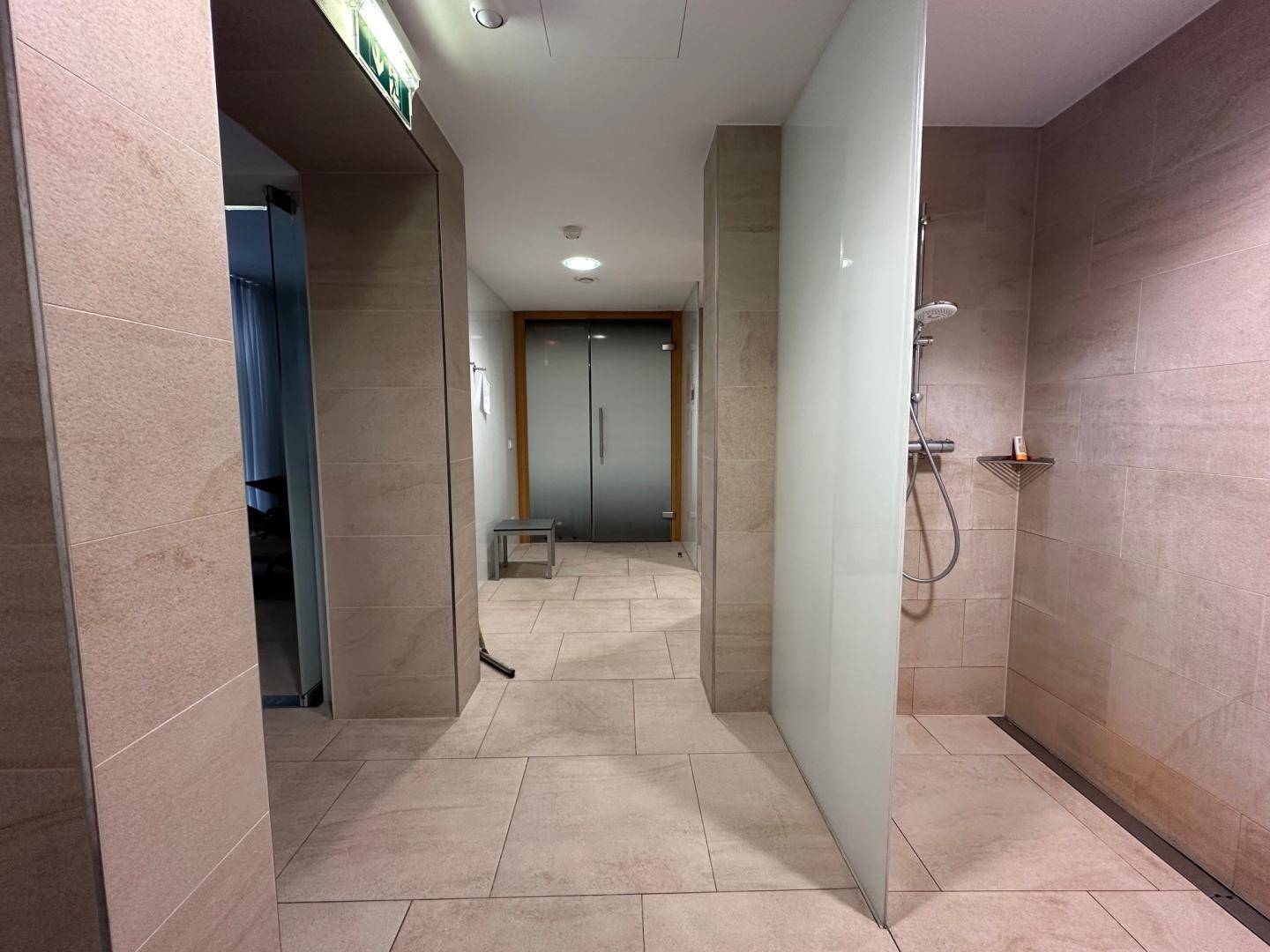 Moderne Duschbereiche mit Fliesen und Glasabtrennungen in einem Wellnessbereich.