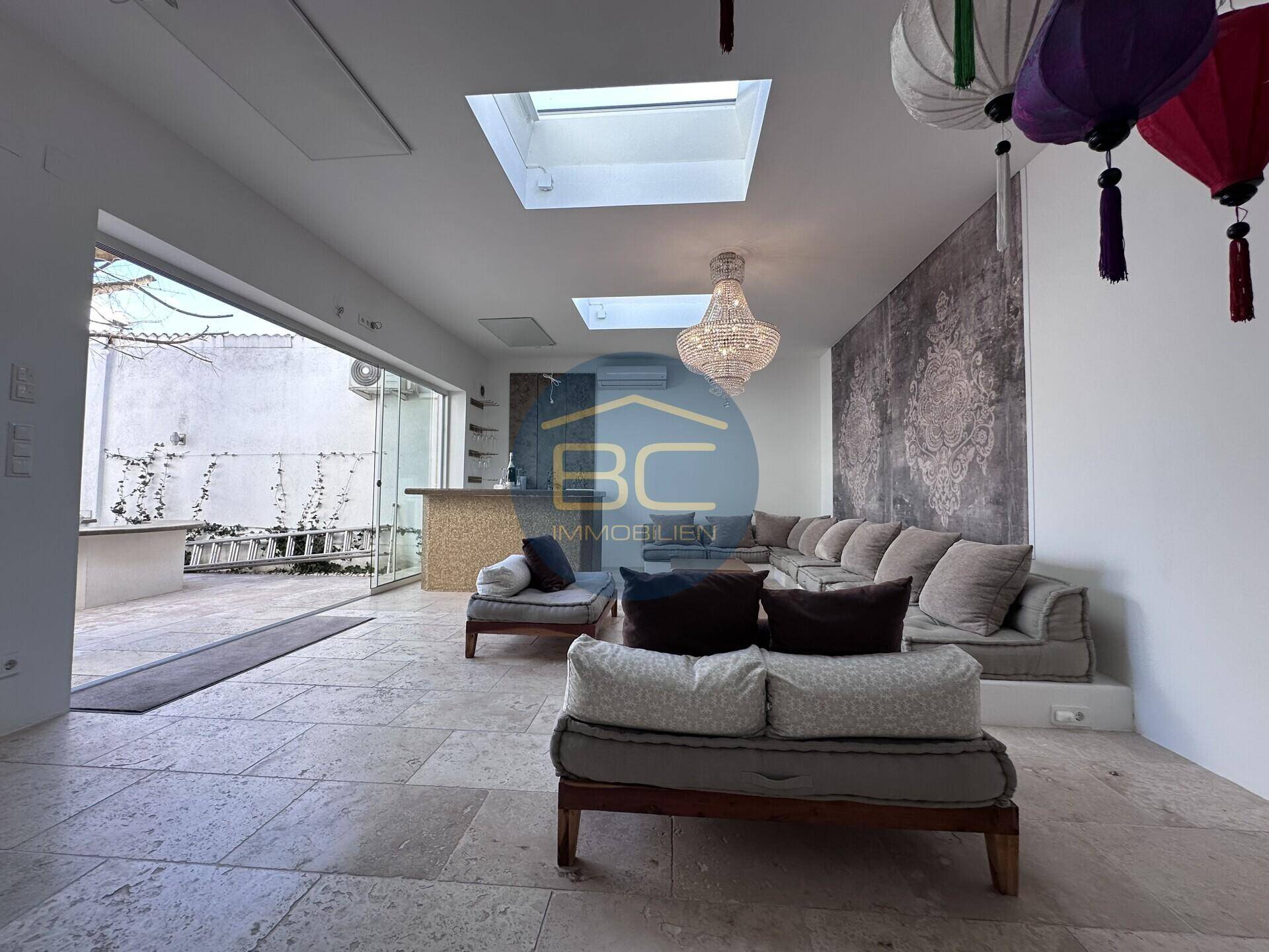 Geräumiger Wohnbereich mit Bar, bequemen Sofas und direktem Zugang zur Terrasse.
