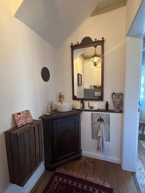 Kleines Gäste-WC mit modernem Waschbecken und rustikalem Holzschrank.