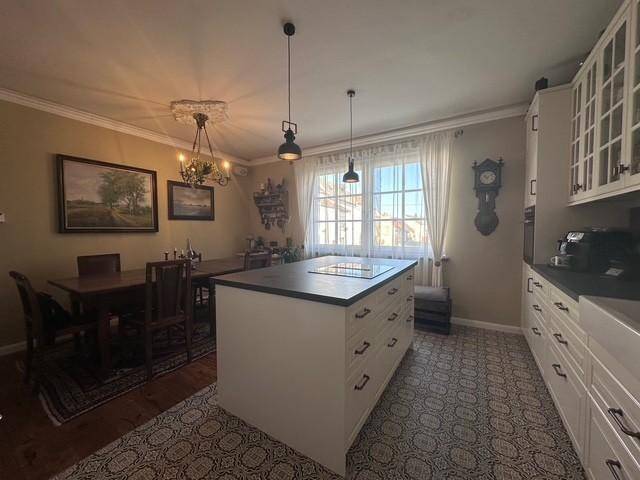 Helle Wohnküche mit Kücheninsel, Esstisch und traditionellen Fliesen auf dem Boden.