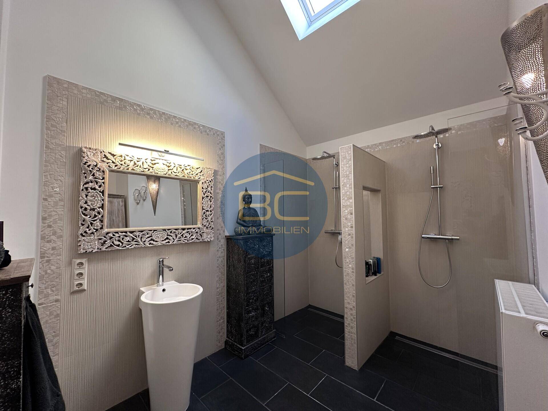 Modernes Badezimmer mit zwei begehbaren Duschen und stilvollem Standwaschbecken.