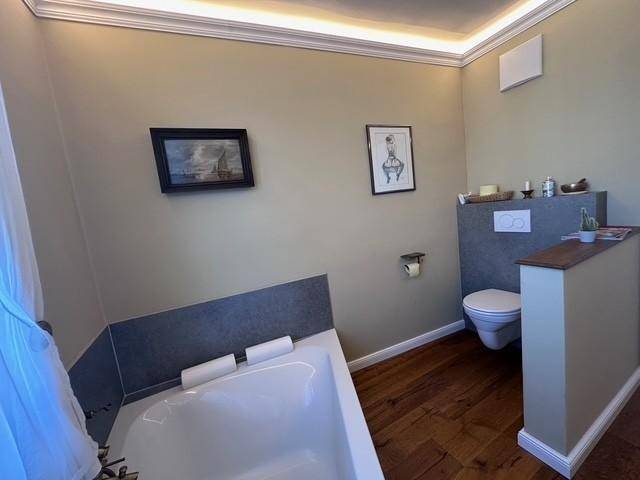 Badezimmer mit Badewanne und Wand-WC, elegant in den Raum integriert.