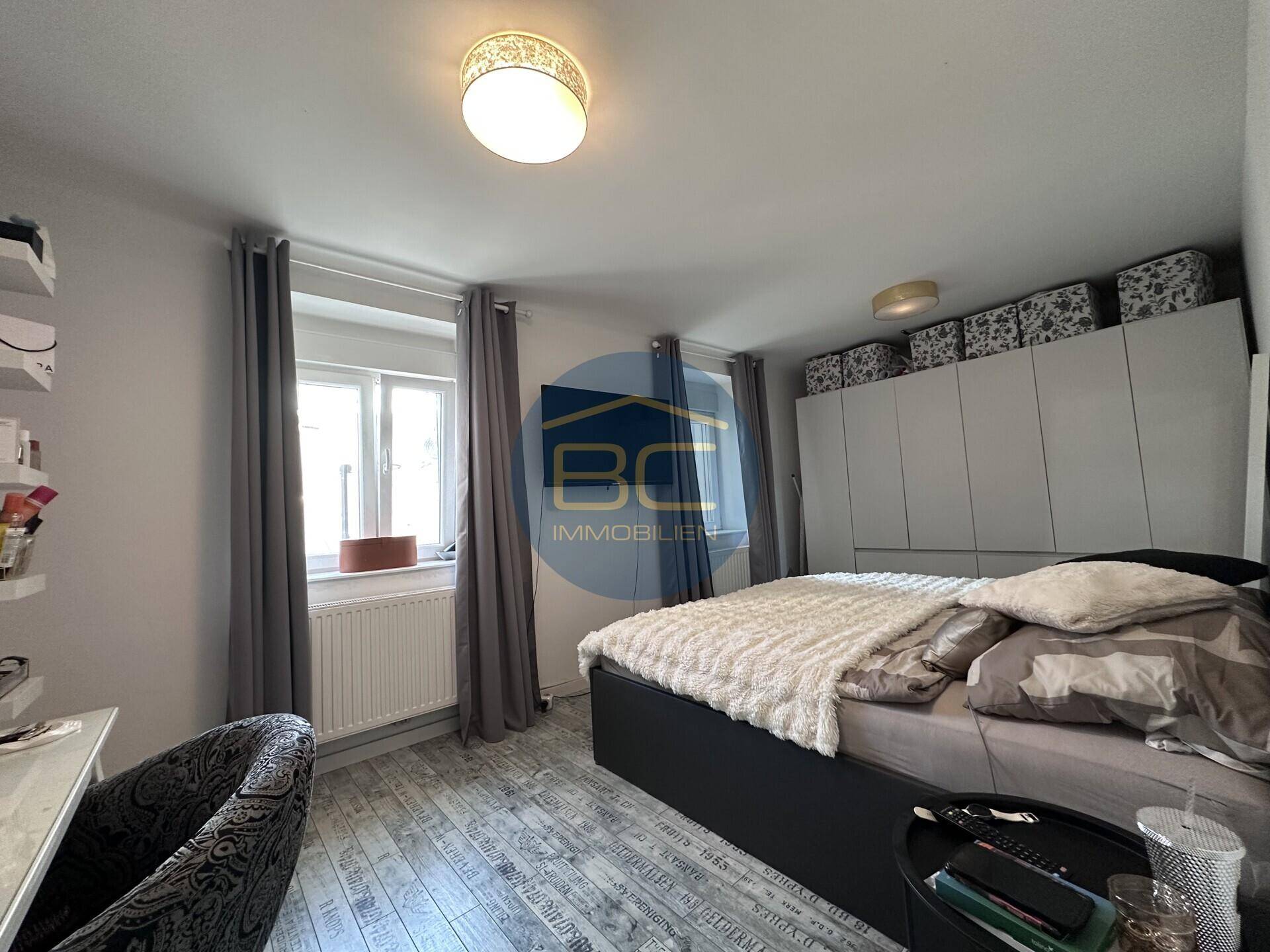 Gemütliches Schlafzimmer mit großem Bett, Einbauschränken und Fenster.