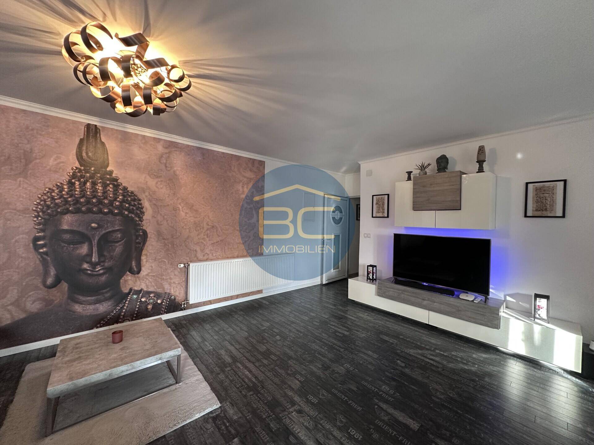 Geräumiger Wohnbereich mit modernem TV-Möbel, bequemer Couch und dekorativer Wand.