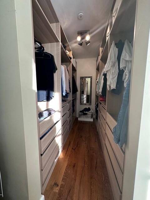 Begehbarer Kleiderschrank mit viel Stauraum und Holzboden.