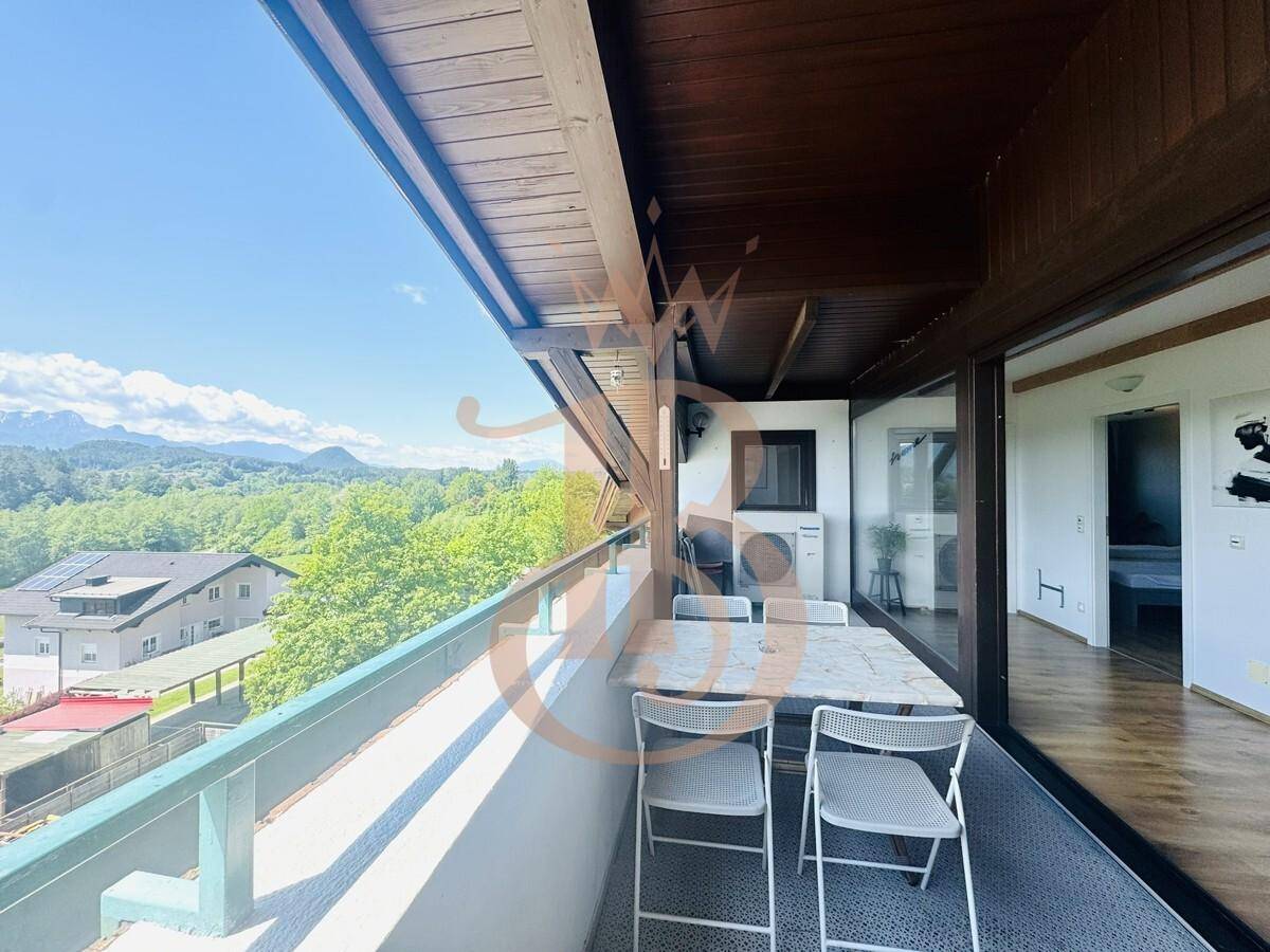 Geräumiger Balkon mit Esstisch und Stühlen, bietet einen herrlichen Blick auf die umliegende Natur.
