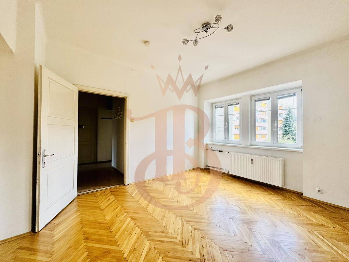 Helles Wohnzimmer mit Fischgrätparkettboden und einer Fensterfront für viel Tageslicht.