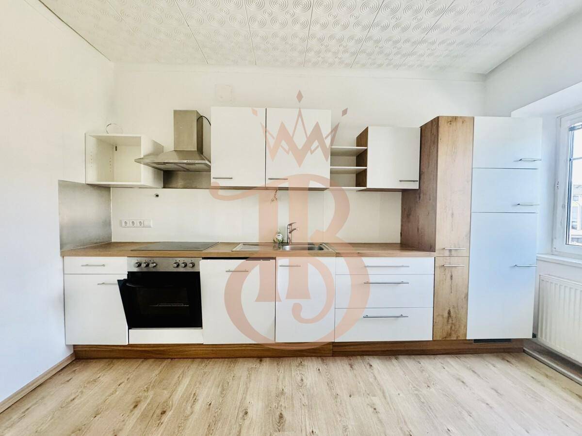 Moderne Einbauküche mit weißen und holzfarbenen Fronten, Kochfeld und Backofen.