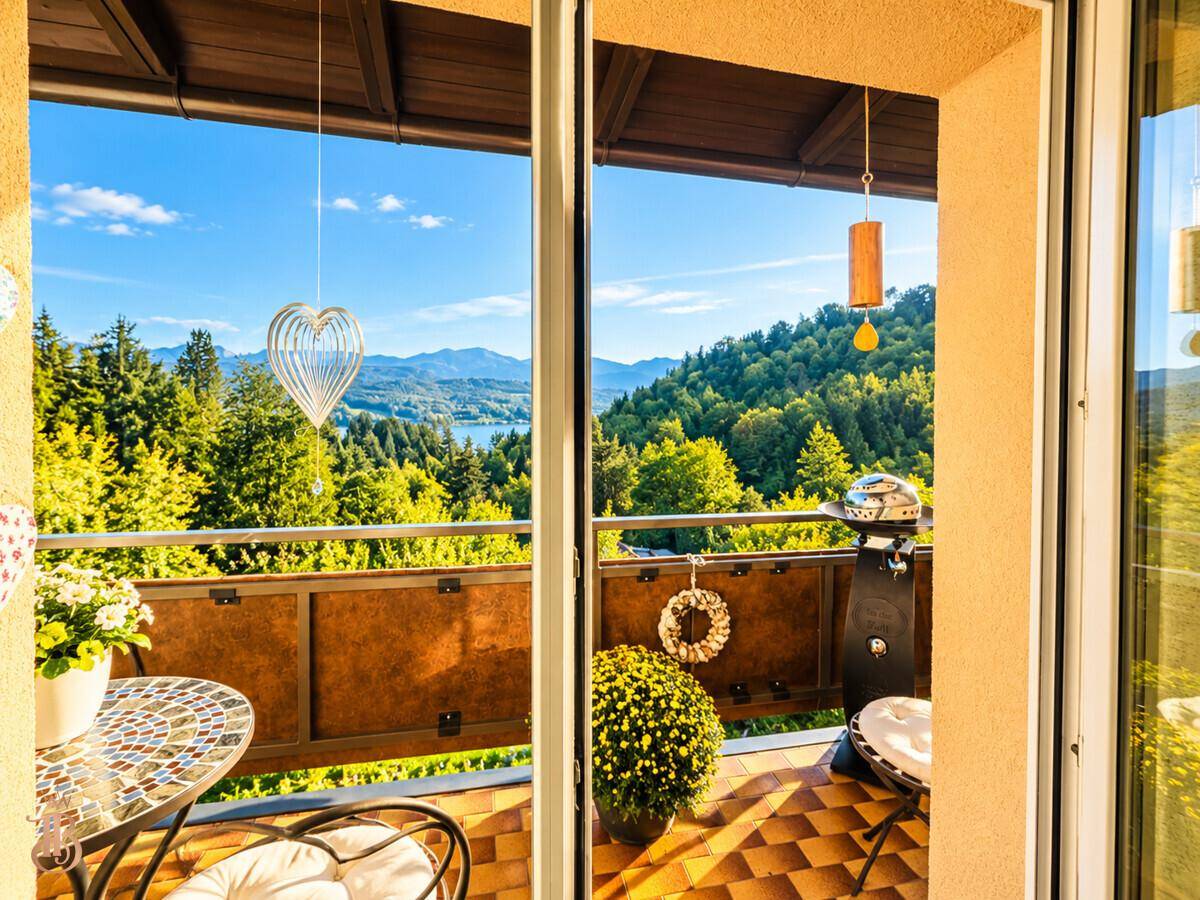 Balkon mit Grill, Dekorationen und einem schönen Ausblick auf den See und die Berge.