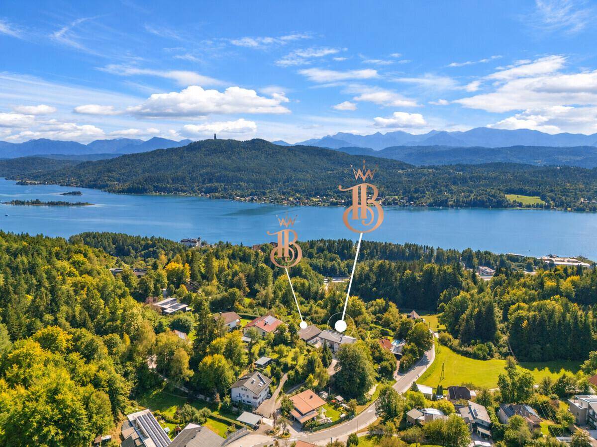 Weitläufige Luftaufnahme der Wohngegend mit Blick auf den See und die umliegende Berglandschaft.