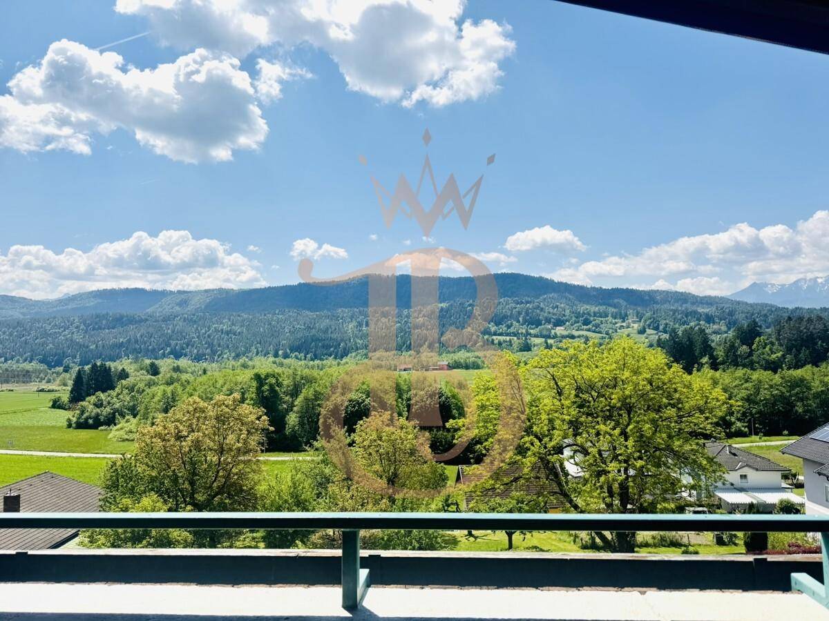 Weitläufiger Ausblick auf die bewaldeten Hügel und Berge unter einem strahlend blauen Himmel.