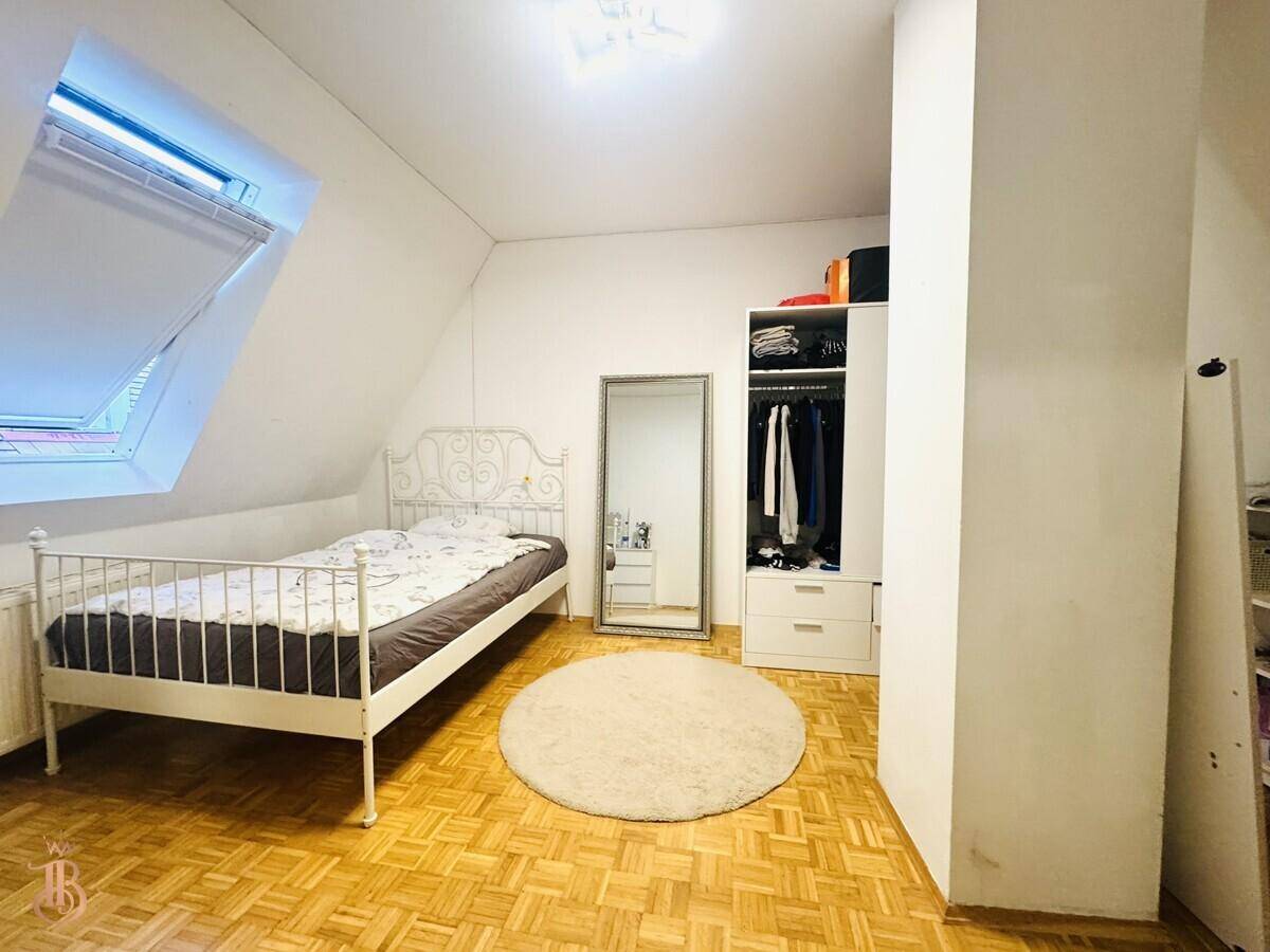 Schlafzimmer im Dachgeschoss mit Dachfenster, Holzboden und einem Kleiderschrank, hell und funktional.
